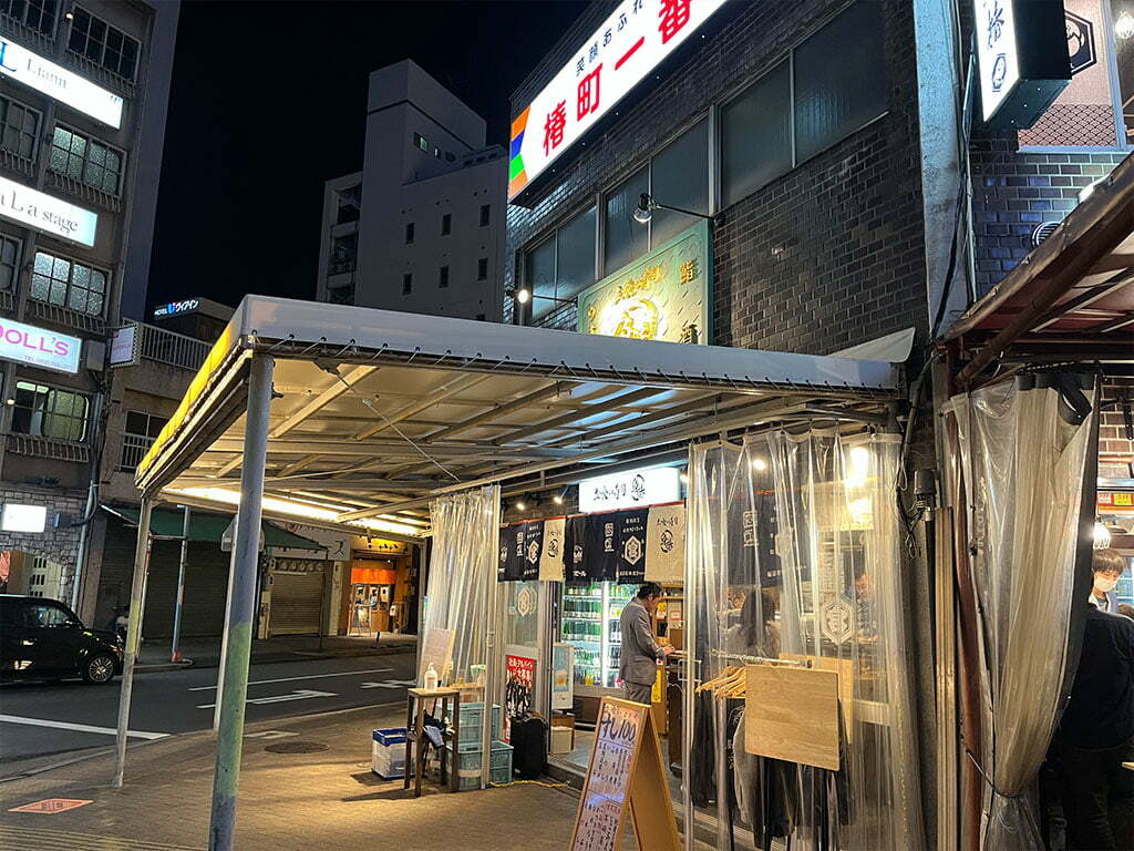 名駅西口・立喰い寿司 魚椿、冷蔵庫からセルフで酒瓶とって呑みながら寿司をつまむ