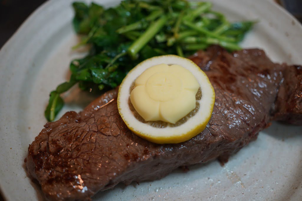 いいバターをつけながら食べる牛赤身肉厚切りステーキ